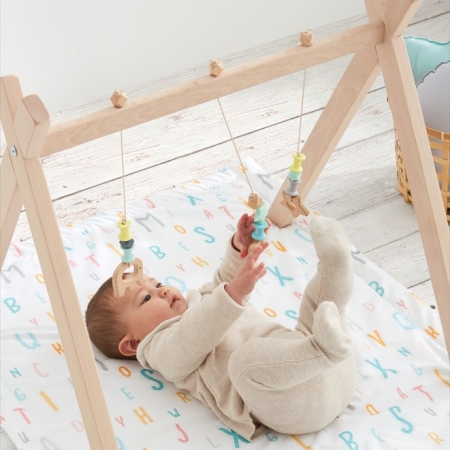 Bebé jugando con gimnasio infantil sobre alfombra acolchada Abecedario tejido 100% algodón orgánico de Estrellita la Valiente