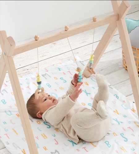Bebé jugando con gimnasio infantil sobre alfombra acolchada Abecedario tejido 100% algodón orgánico de Estrellita la Valiente