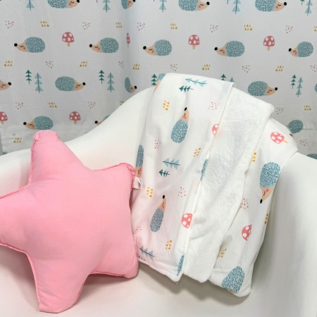 Manta polar Ericete sobre silla con cojín estrella rosa. Estrellita la Valiente. Manta con diseños de erizos.