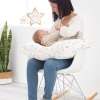 Ambiente bebé lactando sobre un cojín de lactancia ergonómico abecedario algodón orgánico de Estrellita la Valiente. Tejido con motivos de letras del abecedario de varios colores.
