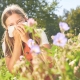 Imagen de una niña tapándose la nariz porque le da alergia el polen de las flores