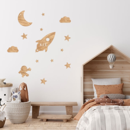 Imagen de la decoración de pared de madera personalizable Espacio de Estrellita la Valiente. Imagen de una habitación infantil con el vinilo personalizable de madera de bosques sostenibles con estrellas, nubes, luna, un astronauta y un cohete.