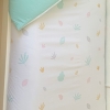 Detalle de Edredón reversible cama naturaleza y mint. Edredón con tejido 100% algodón orgánico con hojas de la naturaleza de varios colores y reversible en mint de Estrellita la Valiente.