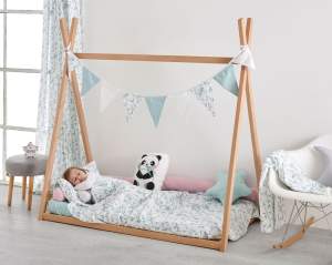 Niña durmiendo en cama con tejidos 100% algodón orgánico