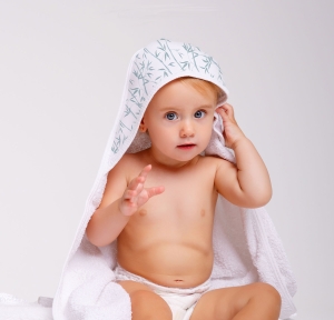 Niña con capa de baño con capucha Bambú. Niña con una capa de baño con dibujos de ramas de Bambú en la Capucha