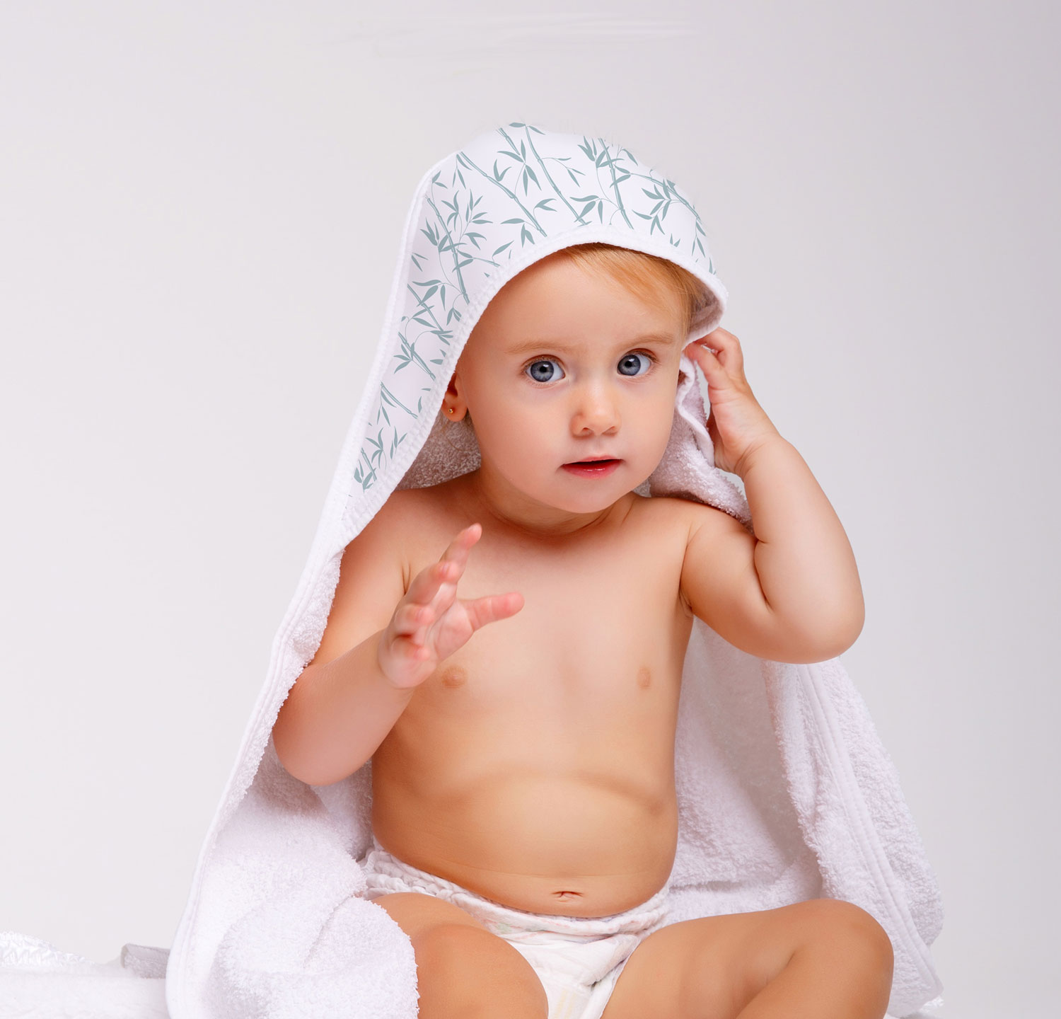 Niña con capa de baño con capucha Bambú. Niña con una capa de baño con dibujos de ramas de Bambú en la Capucha