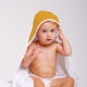 Capa de baño mostaza. Niña con una toalla con capucha de color mostaza.