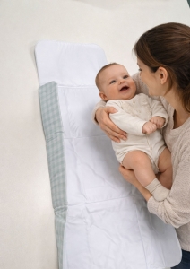 Cambiador plegable cuadro vichy mint Estrellita la Valiente. Mamá intentando colocar a un bebé sobre el cambiador plegable