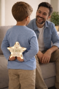 Niño regalando una estrella personalizada a su padre. La lámpara indica Te quiero