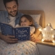 Momento lectura infantil. Un padre leyendo un cuento a su hija