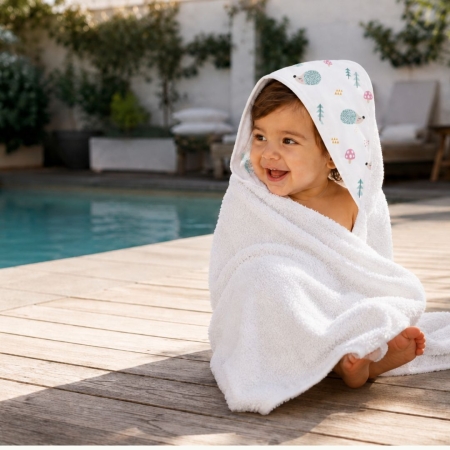 Bebé con capa de baño Ericete en piscina. Capa de baño con estampado de Erizos