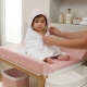 Bebé con capa de baño cuadro vichy rosa sobre bañera. Capa de baño con estampado cuadro vichy rosa