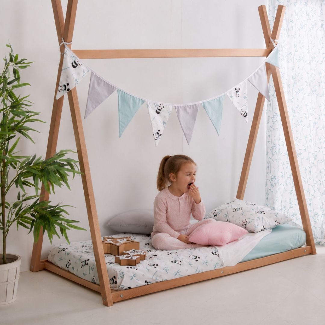 Niña bostezando en cama Estrellita la Valiente. Habitación con una cama Montessori y la niña bostezando sobre la misma