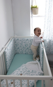 Niña intentando trepar por la cuna